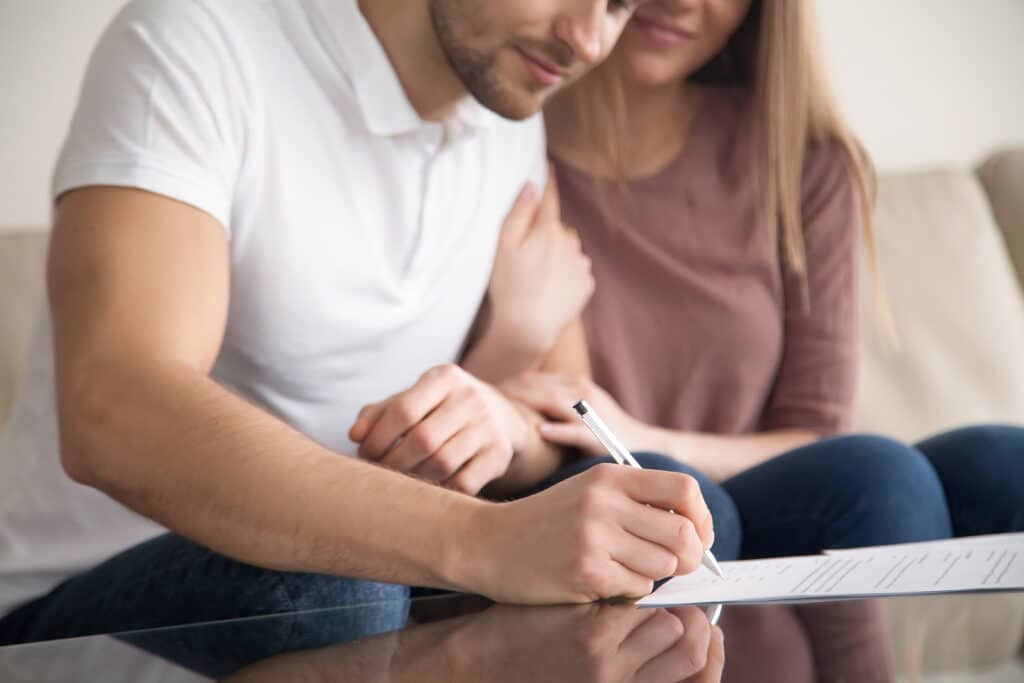 Close up of couple signing documents